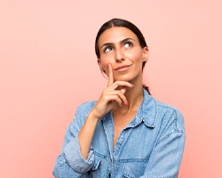 a woman thinking about dental crowns in Dallas