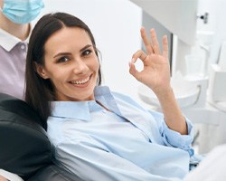a woman smiling and giving the okay sign