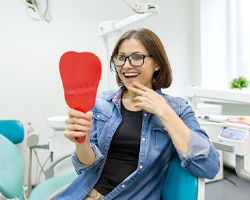 Woman admiring her new dental crown in Dallas