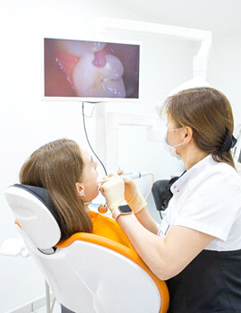 Dental team member using intraoral camera during exam