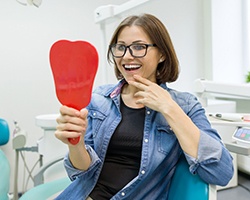 young woman admiring her new dental implants in Dallas, GA