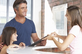 Father and daughter checking into dental office