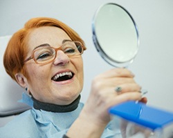 Woman smiles after full-mouth reconstruction in Dallas