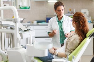 Dentist educating a patient at an exam