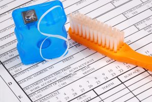 Toothbrush and floss on top of an insurance claim