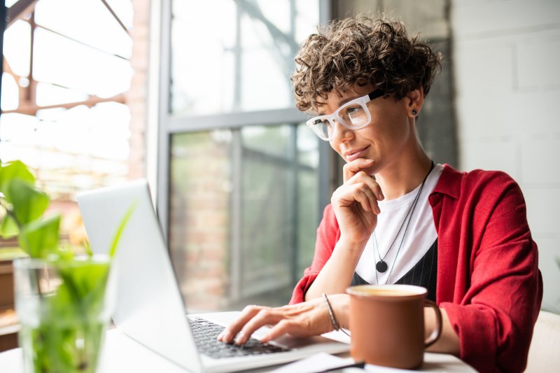 Woman doing research on her computer in apartment