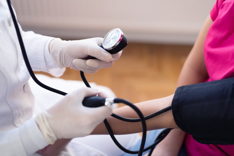 dentist taking a patient’s blood pressure