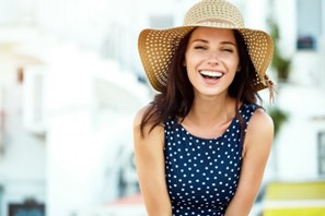 Woman smiling during the summer after receiving teeth whitening treatment.