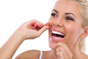 Close up of woman flossing her teeth