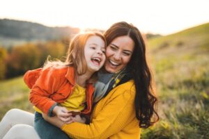 Mother holding child outdoors. 