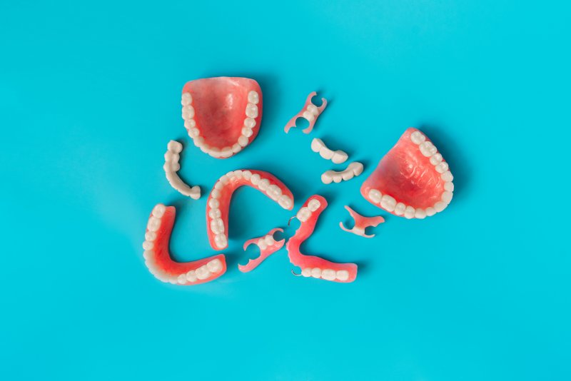 Various dentures and dental bridges against a blue background